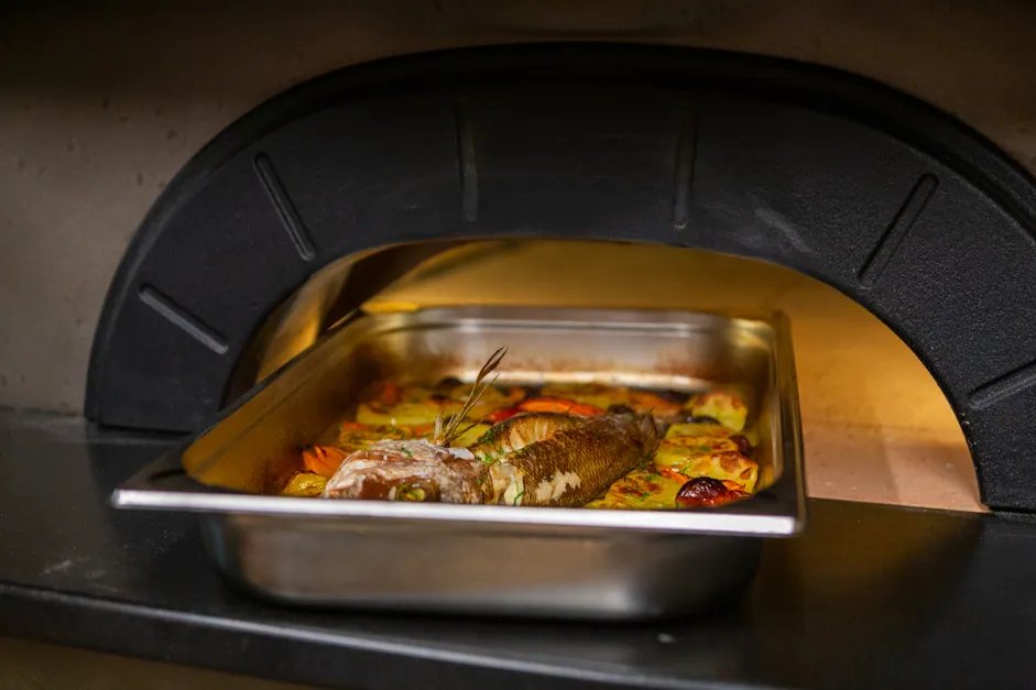 Fish coming out of the wood-fired oven